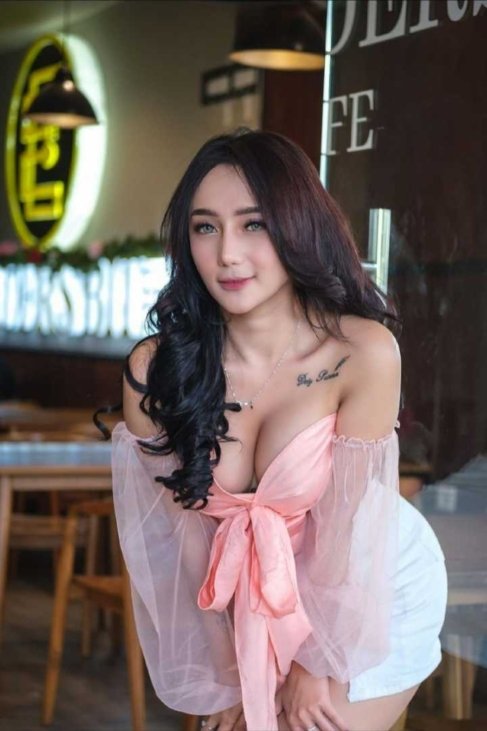 Attractive woman in a pink off-the-shoulder top and white skirt.