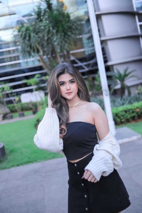 Woman in stylish black skirt and white cardigan