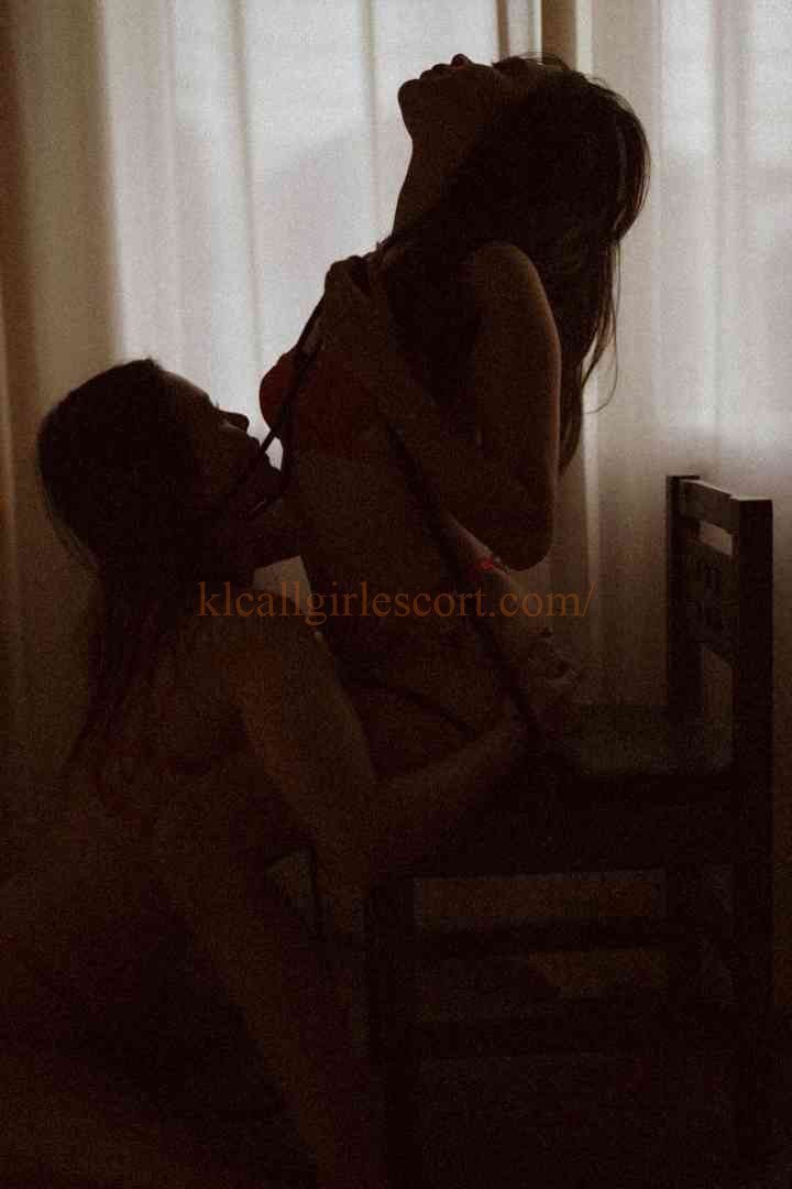 Silhouetted couple embracing near a window with sheer curtains.